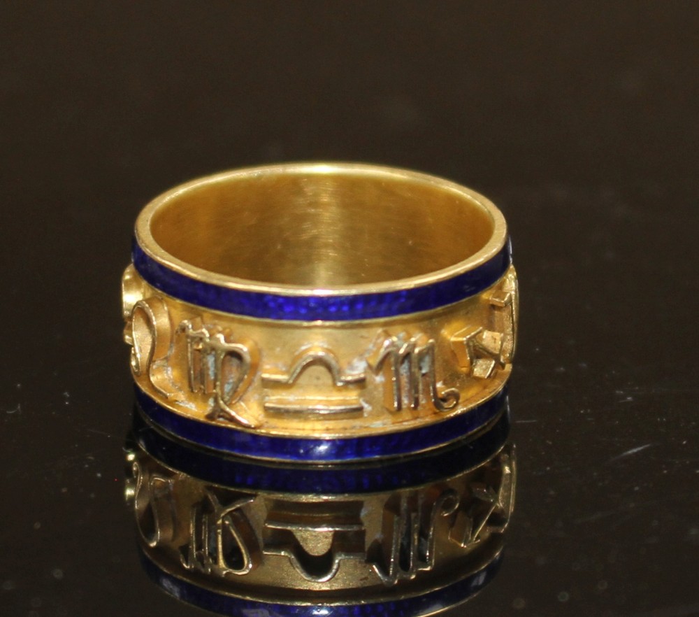 A late Victorian 18ct gold and blue enamel band, decorated in relief with the signs of the Zodiac, Chester, 1896, gross 9.1 grams